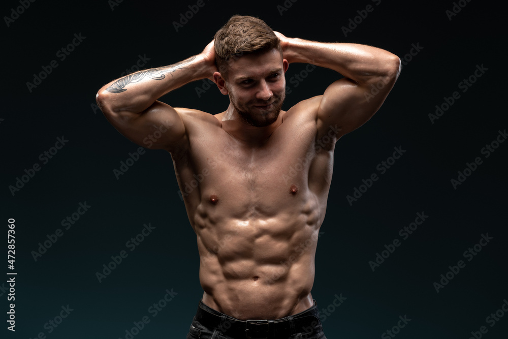 Handsome male athlete is looking away with desire. He is standing and expressing his masculinity. Isolated on black background Handsome male athlete is looking away with desire. He is standing and expressing his masculinity. Isolated on black background