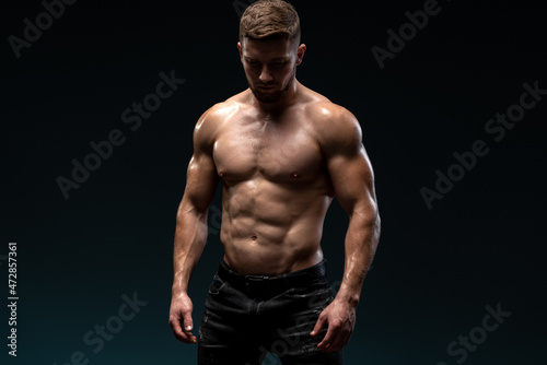 Canvas Print Bodybuilder posing on black background