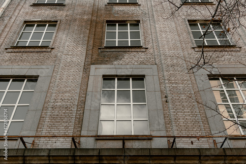 Brick wall with many windows. Bottom view of a brown brick building with many windows