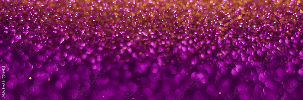 Violet and golden sparkling glitter background, christmas texture. Holiday lights. Abstract defocused header. Wide screen wallpaper. Panoramic web banner with copy space for design