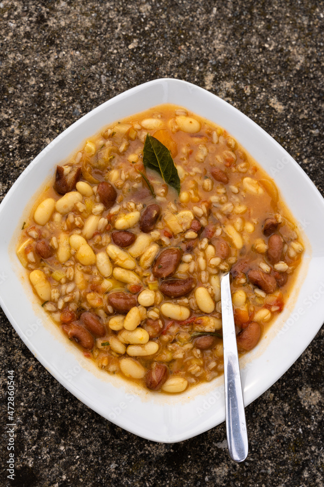 a plate of winter Tuscan bean soup with whole grains. traditional italian cuisine