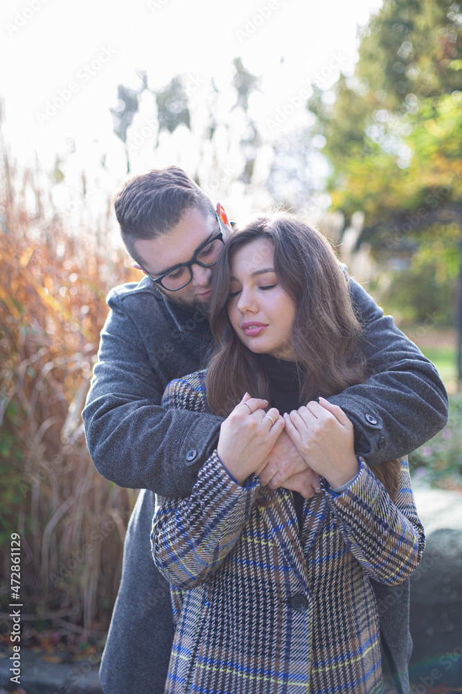 Fototapeta premium Portrait of embracing white young european man and woman near the reeds