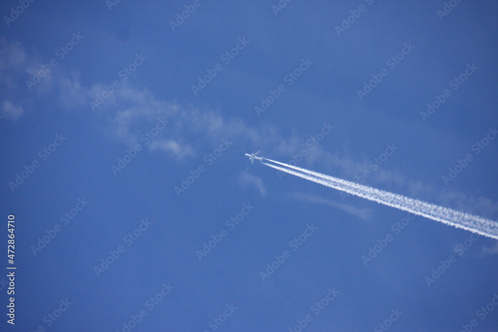 Un avion de ligne qui vol dans le ciel avec des traînées de condensation Un avion de ligne qui vol dans le ciel avec des traînées de condensation