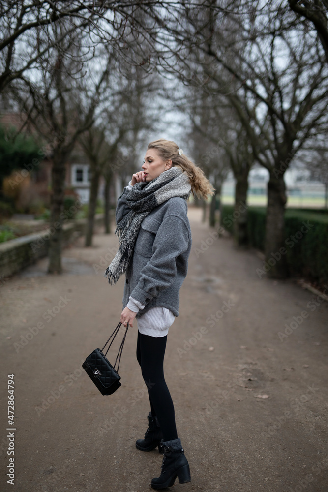 Wunderbare Schöne Frau mit Blondem Haar und Grauen Mantel in der Winter Zeit in Berlin Grüner Sport Platz Wunderbare Schöne Frau mit Blondem Haar und Grauen Mantel in der Winter Zeit in Berlin Grüner Sport Platz