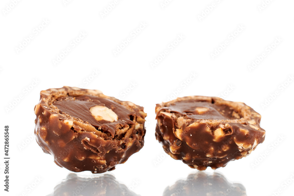 Two halves of chocolate candy with nuts, close-up, isolated on white. Two halves of chocolate candy with nuts, close-up, isolated on white.