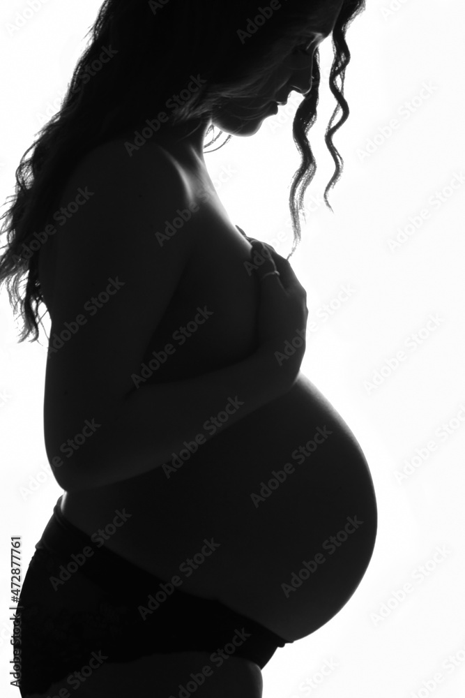 Pregnancy of young woman, profile in backlight. Pregnancy of young woman, profile in backlight.