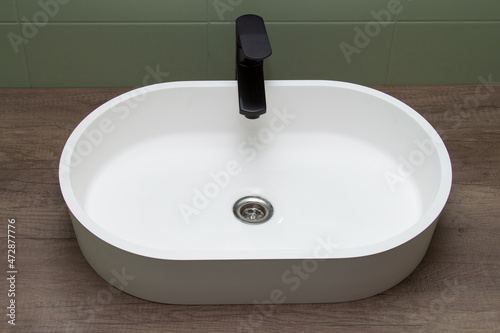 Countertop washbasin with black tap. View from above