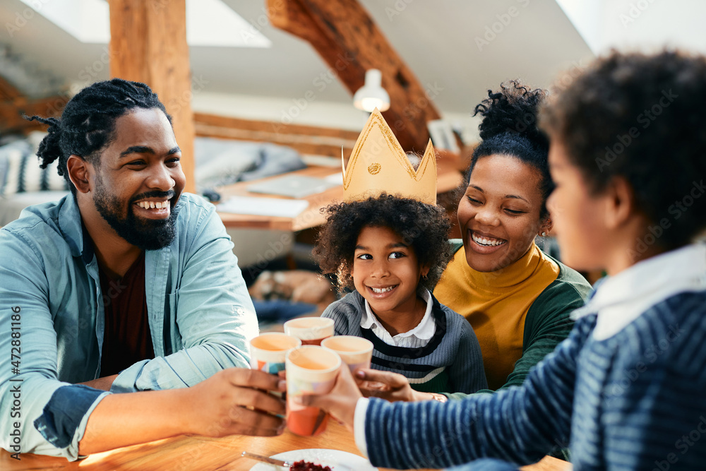 Happy African American family toasts while celebrating little girl's Birthday at home. Happy African American family toasts while celebrating little girl's Birthday at home.