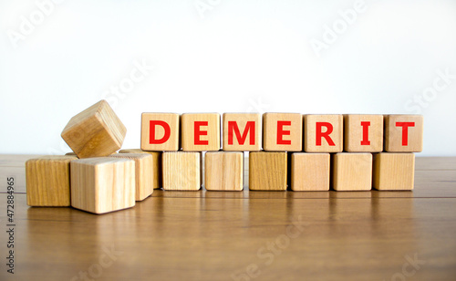 Demerit symbol. The concept word Demerit on wooden cubes. Beautiful wooden table, white background, copy space. Business and demerit concept.