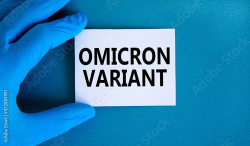 New covid-19 omicron variant strain symbol. Hand in blue glove with white card. Concept words Omicron variant. Medical and COVID-19 omicron variant strain concept. Copy space.
