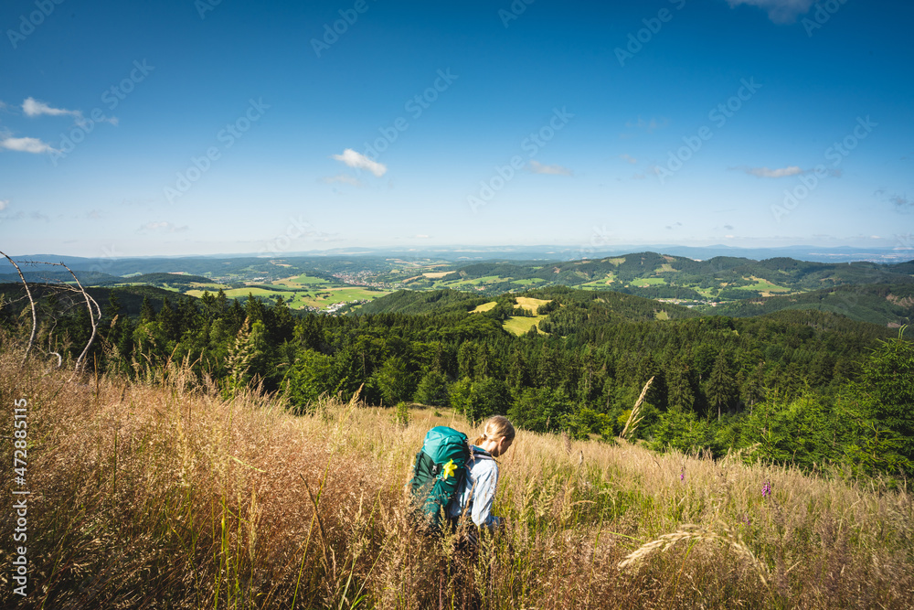 Mädchen mit Rucksack wandert im Thüringer Wald mit Blick auf Floh-Seligenthal
