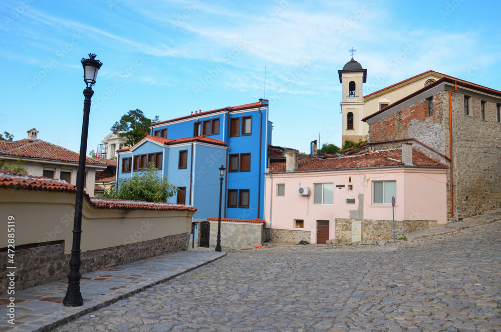 Cobbled street with colorful houses in the center of Plovdiv, Bulgaria. Old town of Bulgarian city. Blue sky.