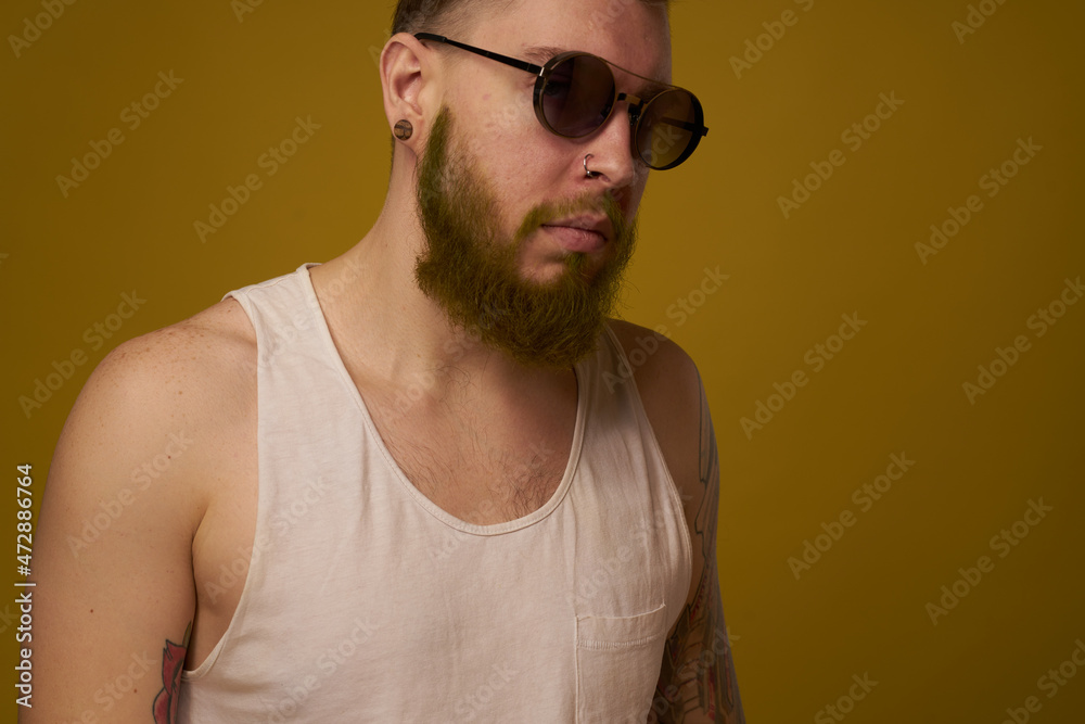 a bearded man with a serious expression in a white t-shirt with tattoos on his arms a bearded man with a serious expression in a white t-shirt with tattoos on his arms