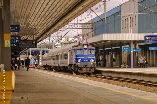 Pociąg osobowy czekający na dworcu kolejowym w Poznaniu po którym chodzą pasażerowie.