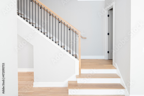 Wallpaper Mural A staircase going up with natural wood steps and handrails, white risers, and wrought iron spindles