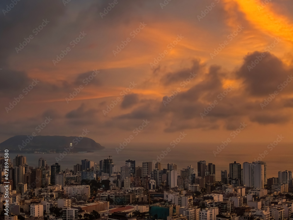 Beautiful drone view over the cityscape of Miraflores District with the Pacific Ocean in background at sunset in Lima, Peru