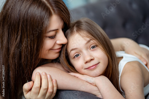 Mom gently hugs the teen's daughter. trust between parents and children