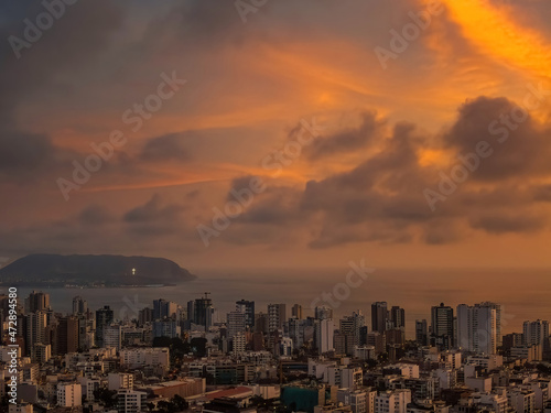 Beautiful drone view over the cityscape of Miraflores District with the Pacific Ocean in background at sunset in Lima, Peru