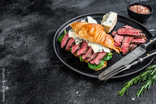 Sandwich with Fillet Mignon meat steak, Croissant and blue cheese. Black background. Top view. Copy space