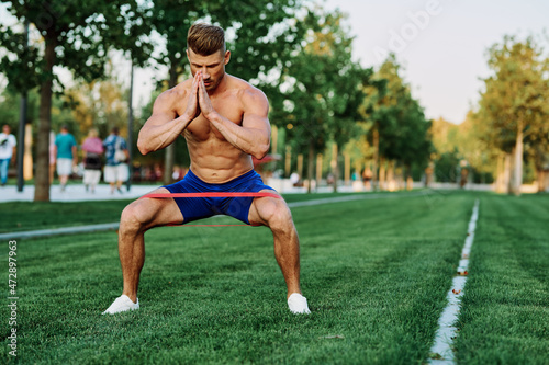athletic man with a pumped up body in the park exercise fitness