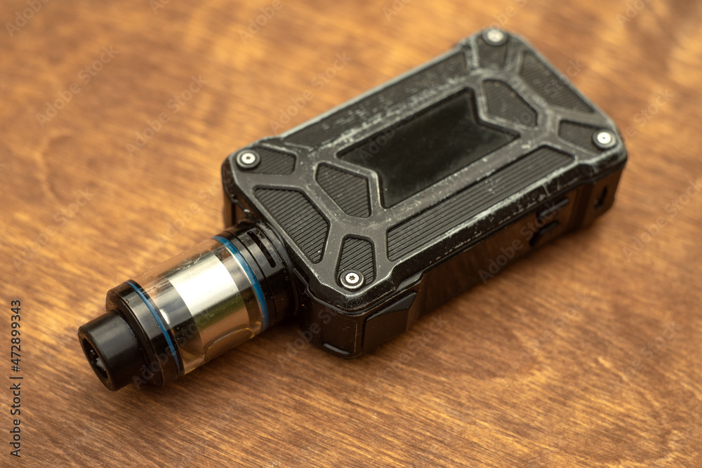 Electronic cigarette on a wooden background.A device for smoking smoke.