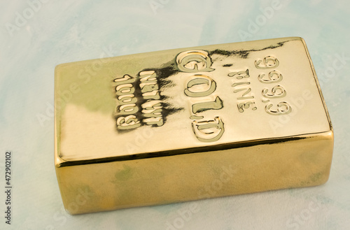 Photo of a 1kg gold bar isolated on a blue background photo