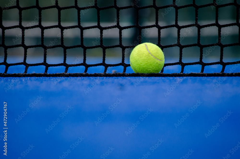 Selective focus. A ball over the net of a paddle tennis court