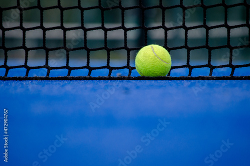 Selective focus. A ball over the net of a paddle tennis court