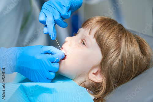 Children dentistry. Liitle girl an dentist examination, teeth cleaning and treatment.