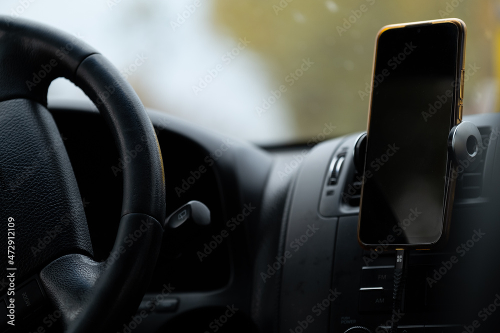 Smartphone in a car use for Navigate or GPS. Driving a car with Smartphone in holder. Copy space. Empty space for text. car interior details.