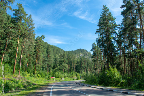 asphalt road between mountain peaks. Clear sunny summer day