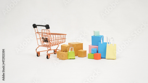 miniature trolley filled with colorful boxes and mini bags isolated on white background