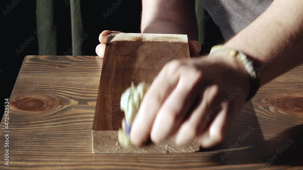 man applying wood stain. applying oil on a wooden board. application of wood impregnation. protection of the wooden surface man applying wood stain. applying oil on a wooden board. application of wood impregnation. protection of the wooden surface