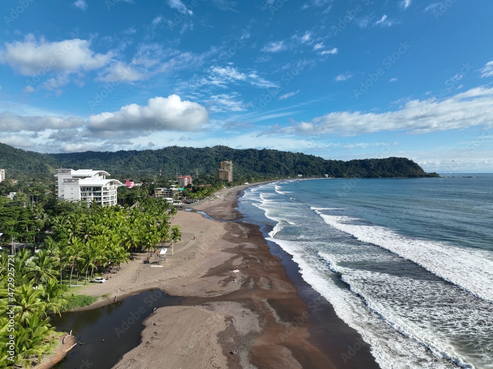 Jaco Beach Costa Rica, surfers paradise with beach chairs and long beach with crashing waves	