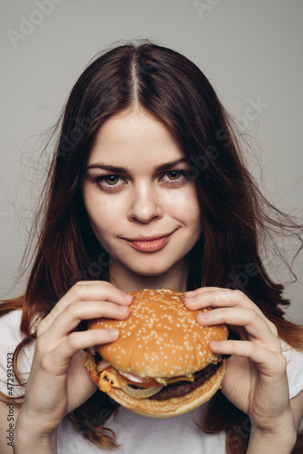 woman with a hamburger in her hands a snack fast food close-up