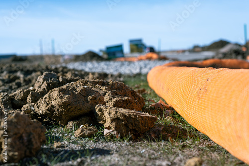 Photography selective focus on filter sock around exposed dirt at a construction site to pre