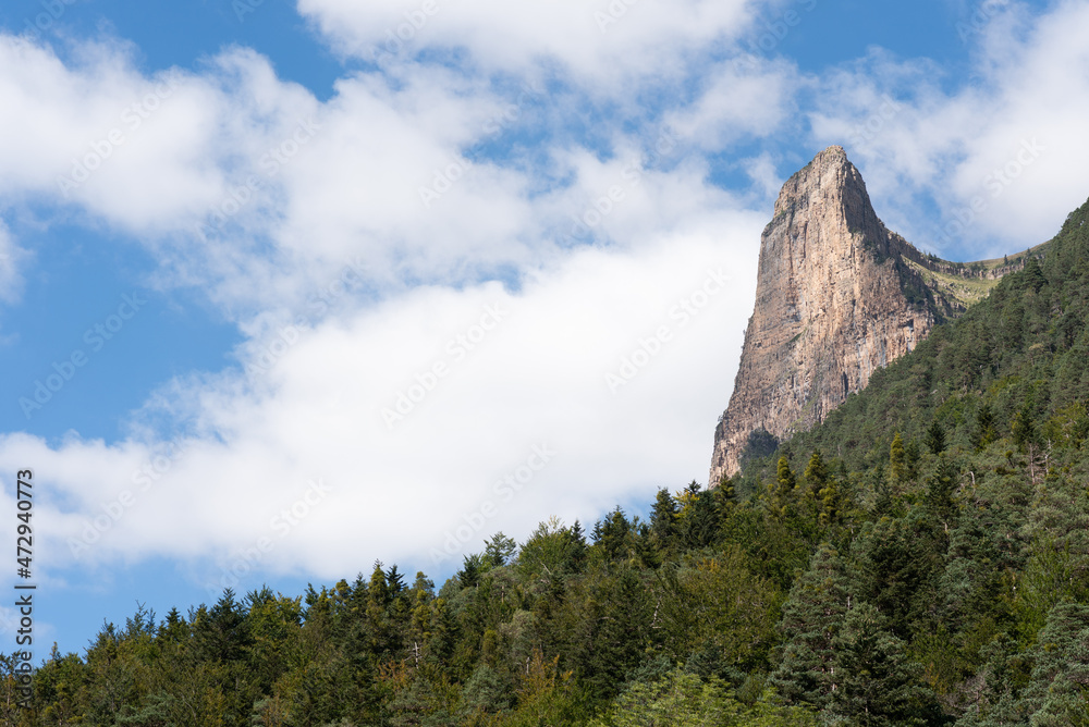 Mallo needle between clouds and vegetation, famous for climbing. Mountain peak in Ordesa National Park, Huesca. Mallo needle between clouds and vegetation, famous for climbing. Mountain peak in Ordesa National Park, Huesca.