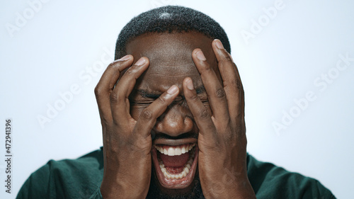 Shocked african american man screaming in light background. Afro guy shouting photo