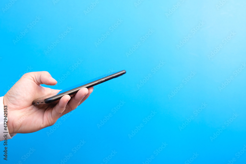 Hand holding a smartphone, poster, businessman or manager holding a phone against a yellow background, internet marketing. Hand holding a smartphone, poster, businessman or manager holding a phone against a yellow background, internet marketing.