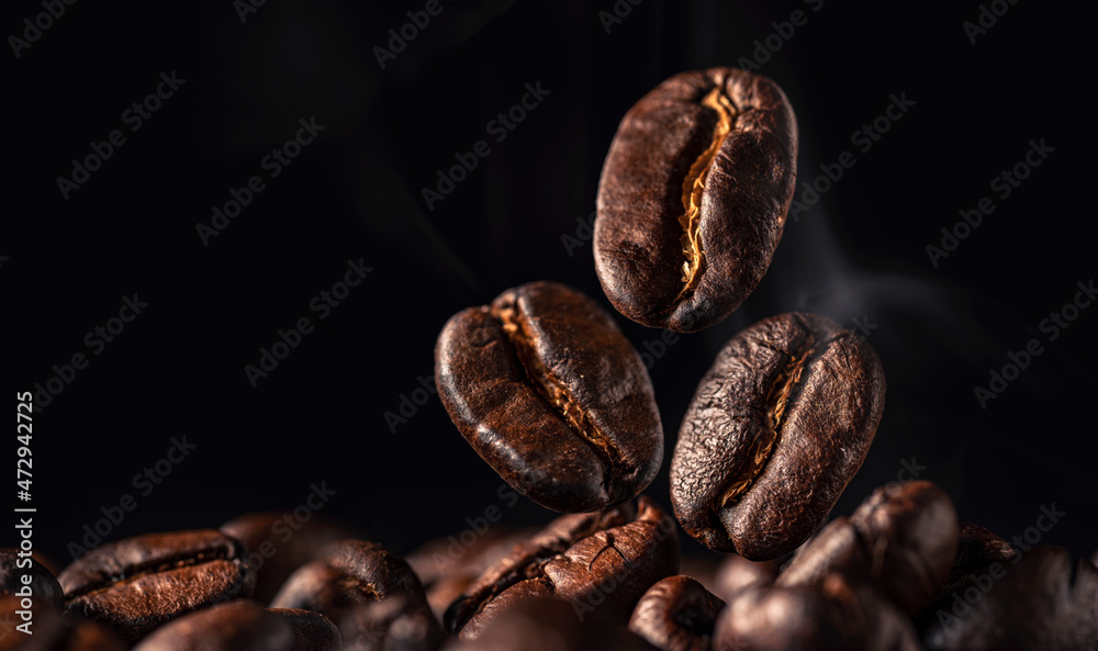 Coffee beans with smoke on black background , Freshly Roasted coffee beans