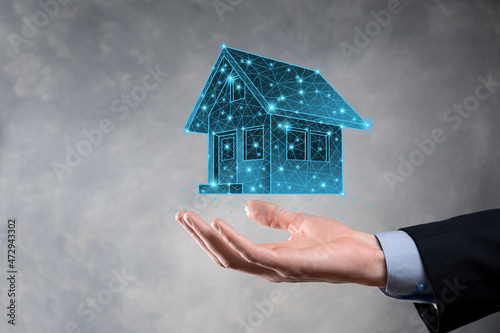 Man hold low polygon.Real estate concept, businessman holding a house icon.House on Hand.Property insurance and security concept. Protecting gesture of man and symbol of house