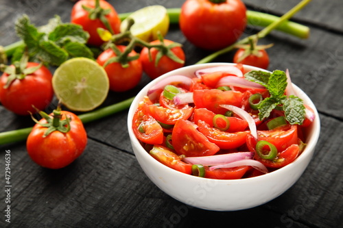 Homemade delicious fresh organic tomato salad with exotic herbs.