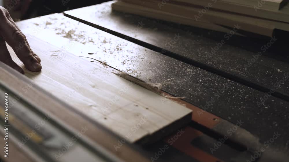 carpenter work with machine circular saw. electric saw machine blade and board in a wood shop. workers sawing boards with a circular saw carpenter work with machine circular saw. electric saw machine blade and board in a wood shop. workers sawing boards with a circular saw