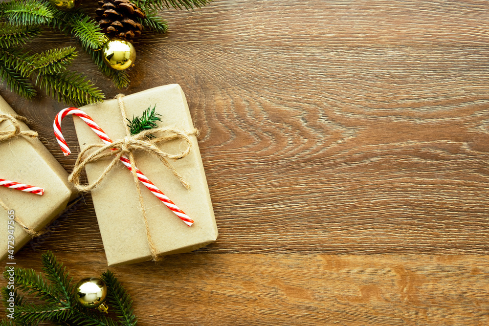 Beautiful Christmas background with two gift boxes, decorate with pine branch and pine cone over wood background. Top view with copy space, flat lay. Beautiful Christmas background with two gift boxes, decorate with pine branch and pine cone over wood background. Top view with copy space, flat lay.