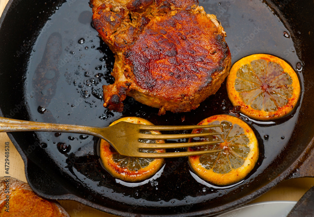 Φωτογραφία pork chop seared on iron skillet