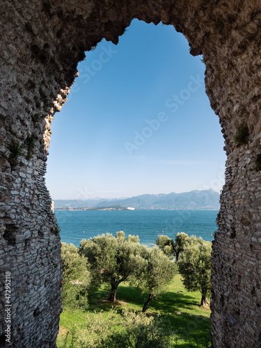 Lake Garda and Stone Arch of Grottoes of Catullus Roman Villa Ruins in Sirmione, Italy photo