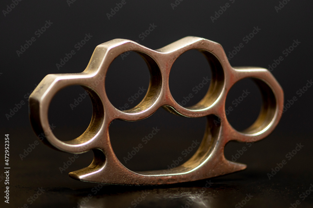 Steel brass knuckles on a black background with reflections