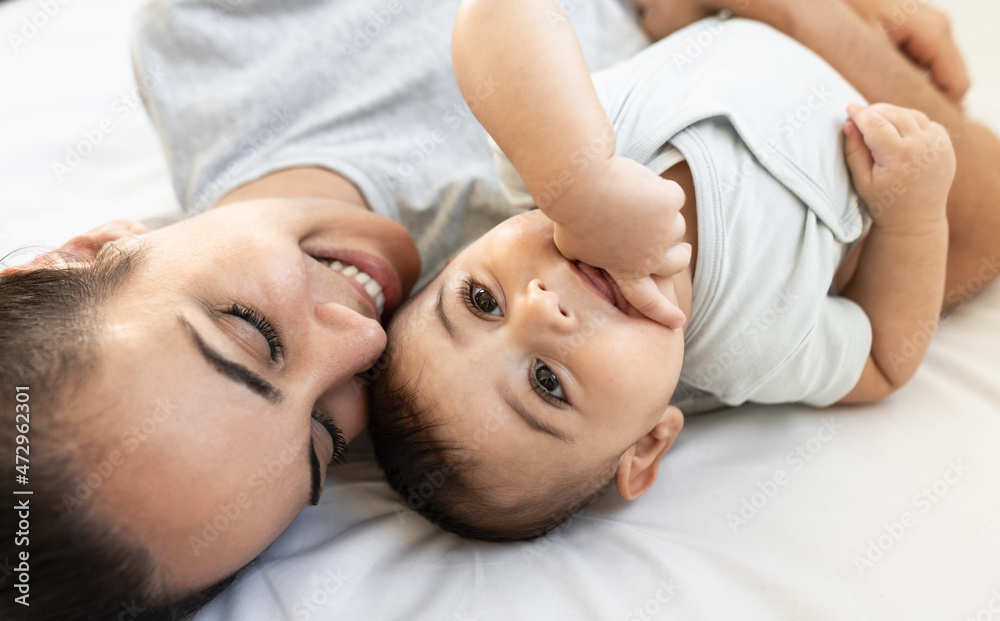 Happy mother lying on bed with her little baby - Family and Maternity concept Happy mother lying on bed with her little baby - Family and Maternity concept