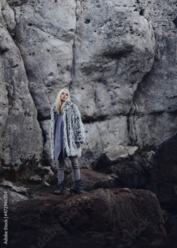 Fototapeta Naklejka Na Ścianę i Meble -  Fashion shooting in nature, a girl model in a fur coat made of artificial fur.