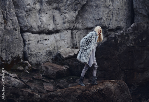 Fashion shooting in nature, a girl model in a fur coat made of artificial fur. © Streetstylephoto